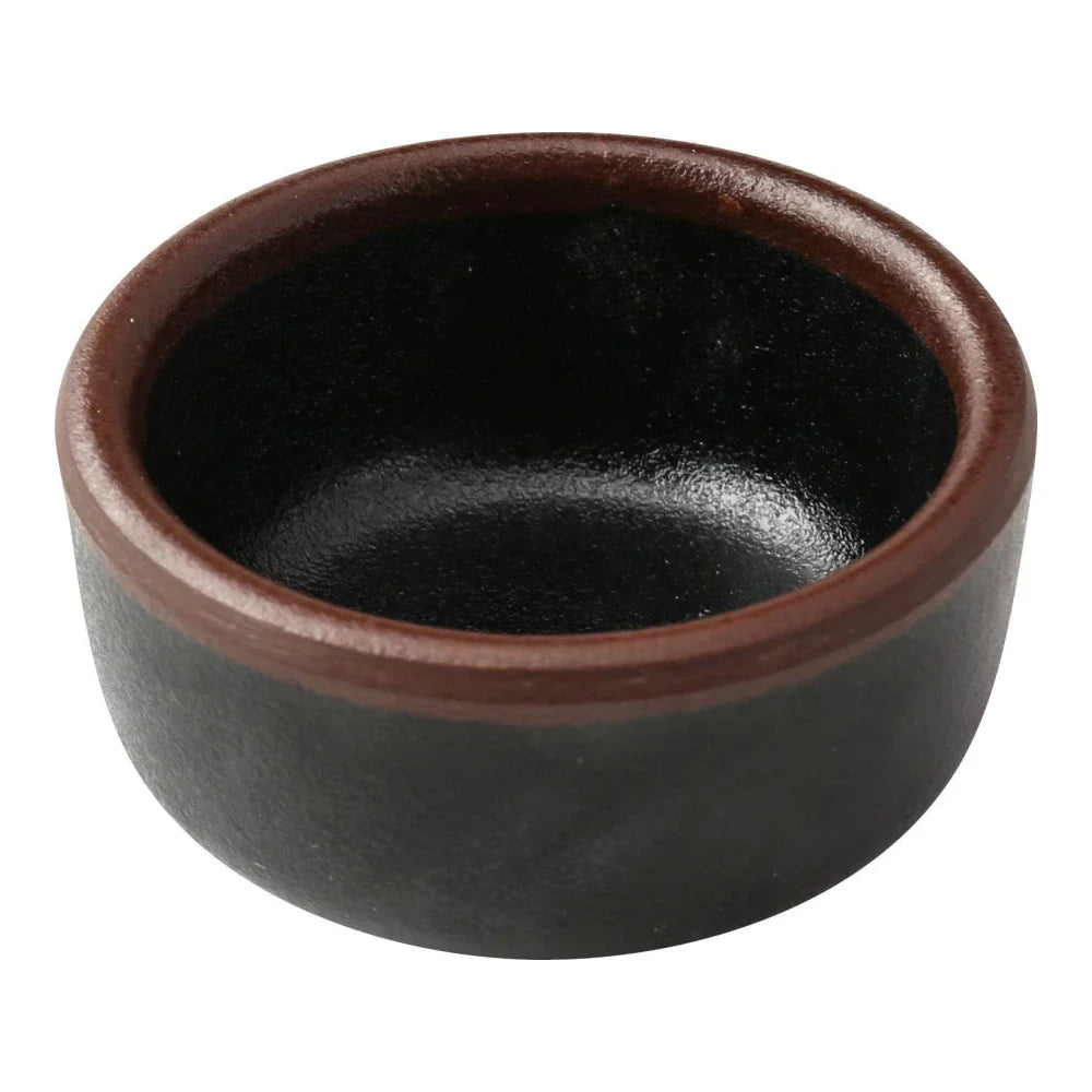 Yanco Sauce Dish NA-5002BK Made from high-quality melamine, this server is both durable and lightweight. Its round shape and break-resistant nature make it suitable for frequent use in commercial dining environments. This server is designed to be dishwasher safe, ensuring convenient and efficient cleaning, essential for high-turnover settings. The black color with a speckled finish and brown rim adds a sophisticated touch to the presentation of sauces and condiments.