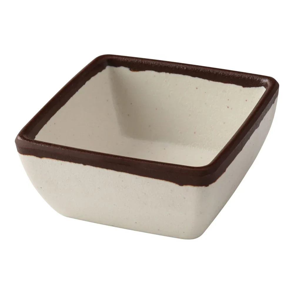 Yanco Square Sauce Dish NA-5004 Made from high-quality melamine, this server is durable and lightweight. Its square shape and break-resistant nature make it ideal for frequent use in commercial dining settings. This server is designed to be dishwasher safe, ensuring easy and efficient cleaning, which is essential for high-turnover environments. The ivory color with a speckled finish and brown rim adds a touch of elegance to the presentation of sauces and condiments.