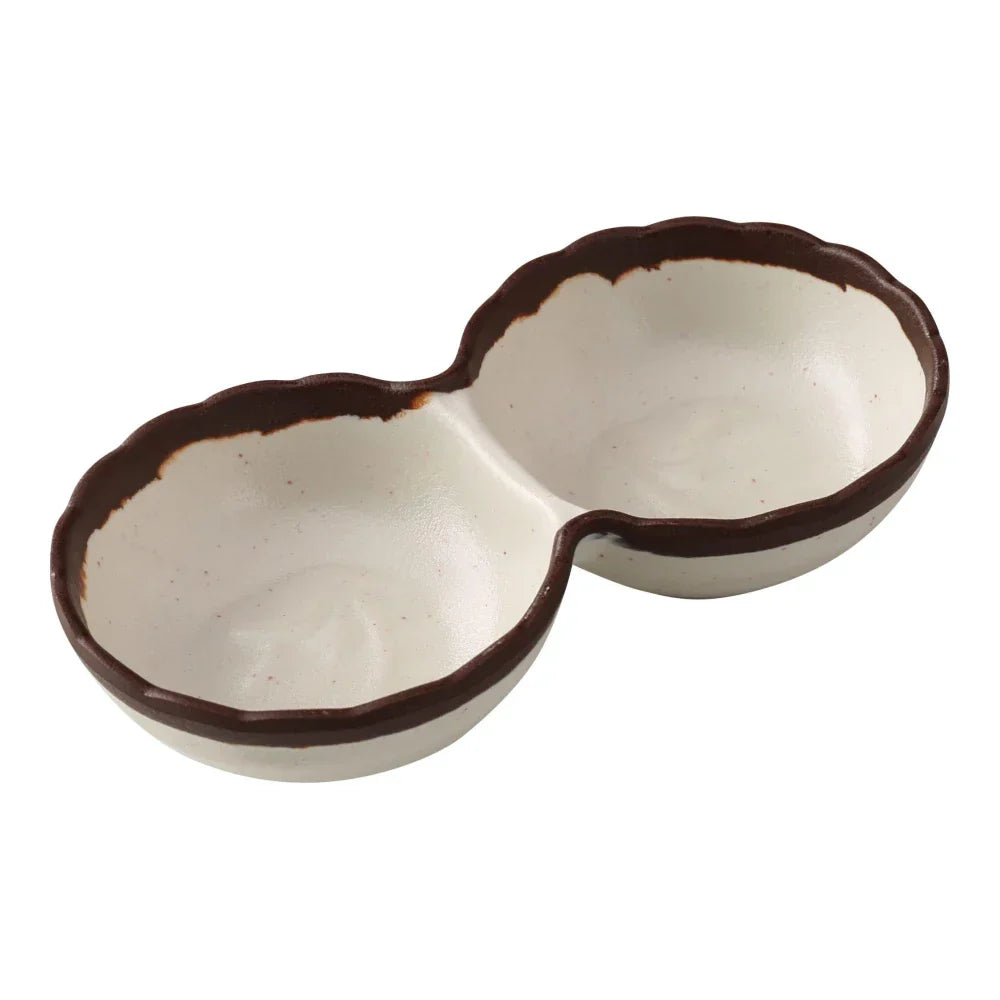 Yanco Two-Divided Sauce Dish NA-506 Made from durable melamine, it is designed for break resistance and easy handling. This server features two compartments, each with a capacity of 2 ounces, suitable for serving various condiments or sauces. The design includes an ivory color with a speckled brown rim, adding an attractive touch to the table. It is dishwasher safe, which ensures convenient and thorough cleaning, though it is not microwave safe. 