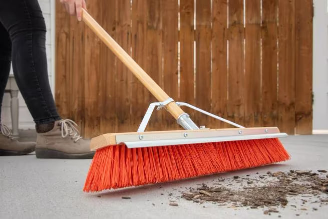 24 Inch Orange Flo-Pac Polypropylene Floor Sweep with a steel scraper blade for removing caked-on debris. Includes handle, brace and handle connection for heavy duty commercial and industrial cleaning.