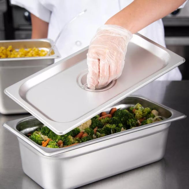 Protect food with the DuraPan Stainless Steel Steam Table Hotel Pan Handled Cover 1/3 Size 607130C. Features heavy gauge stainless steel construction, a comfortable concave handle, and dishwasher-safe cleaning.